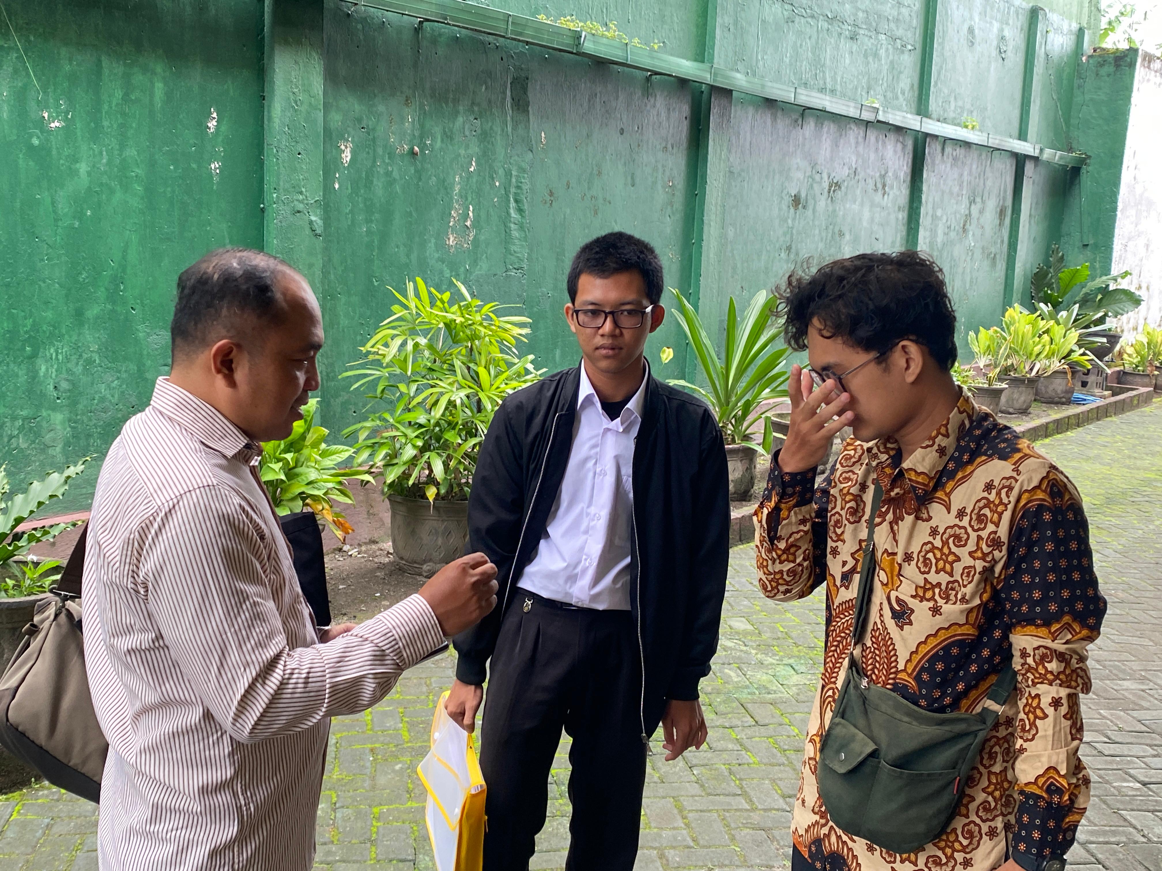 Penasihat hukum (PH) Pujianto sedang berbincang-bincang dengan Faiz  sebelum sidang dimulai.