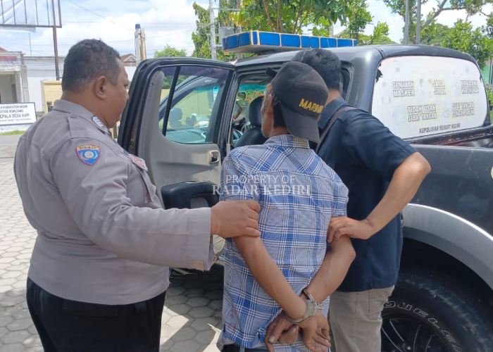 MENYERAH: Anggota Polsek Kunjang menggelandang Kusnadi yang Rabu (21/1) lalu menyerahkan diri setelah menusuk Tumiyatun, 69, ibunya. Penyidik kesulitan memeriksa pria yang terus meracau saat dimintai.