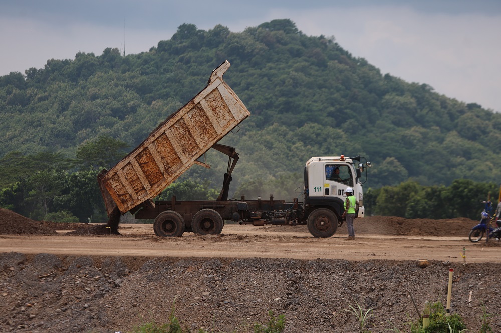 Pekerja proyek melakukan pengurukan tanah di wilayah Kelurahan Bujel, Mojoroto. Kawasan itu terdampak trase jalan tol akses Bandara Dhoho Kediri.