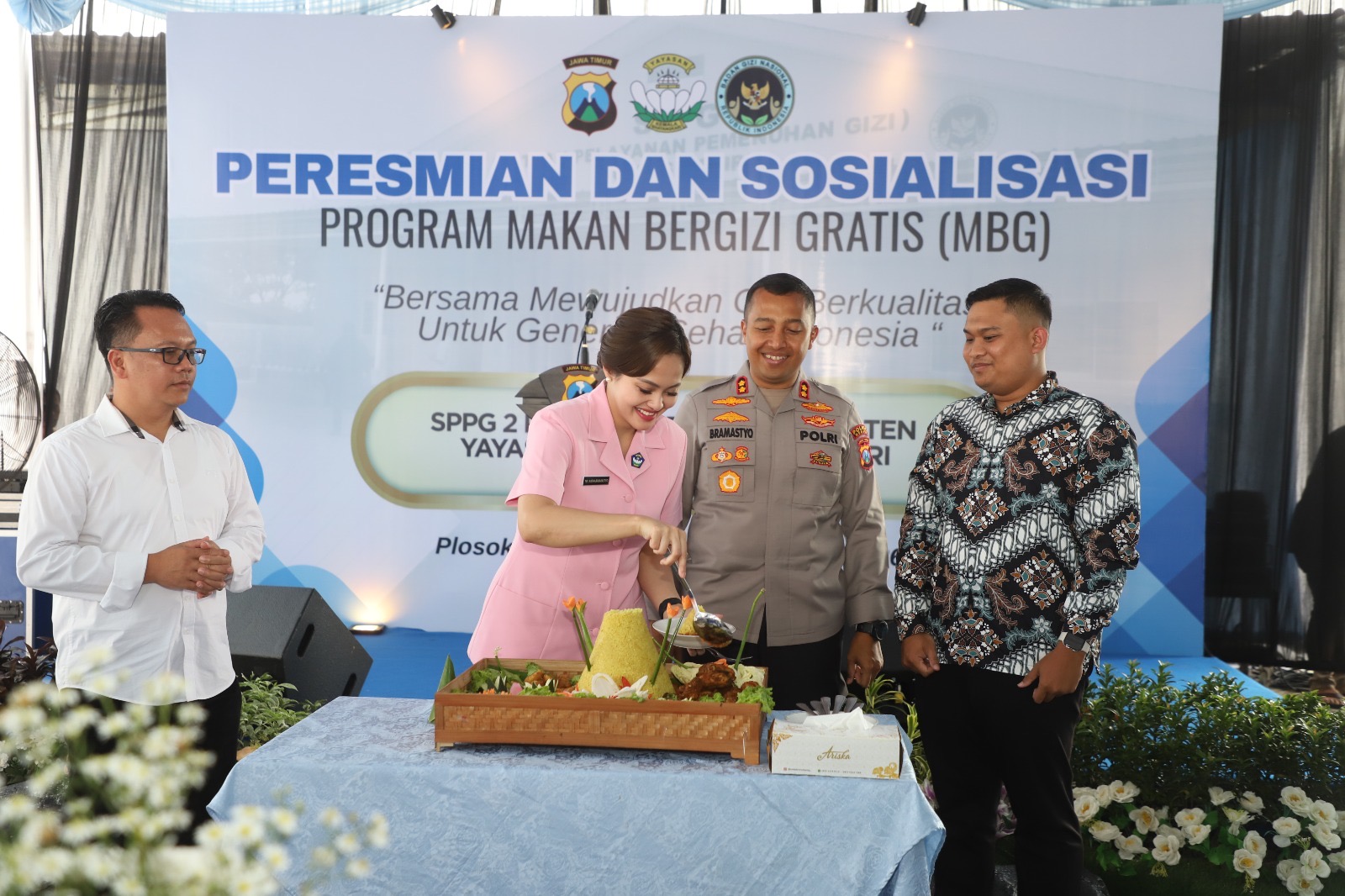 MULAI BEROPERASI: Kapolres Kediri AKBP Bramastyo Priaji melakukan seremoni pemotongan tumpeng dalam peresmian SPPG 2 Polres Kediri di Mapolsek Plosoklaten kemarin.