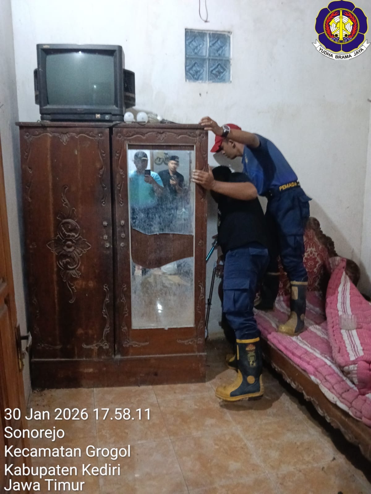 Petugas damkar sedang mengevakuasi ular di rumah warga Grogol. (Foto: Bidang pencegahan kebakaran satpol PP Kabupaten Kediri)