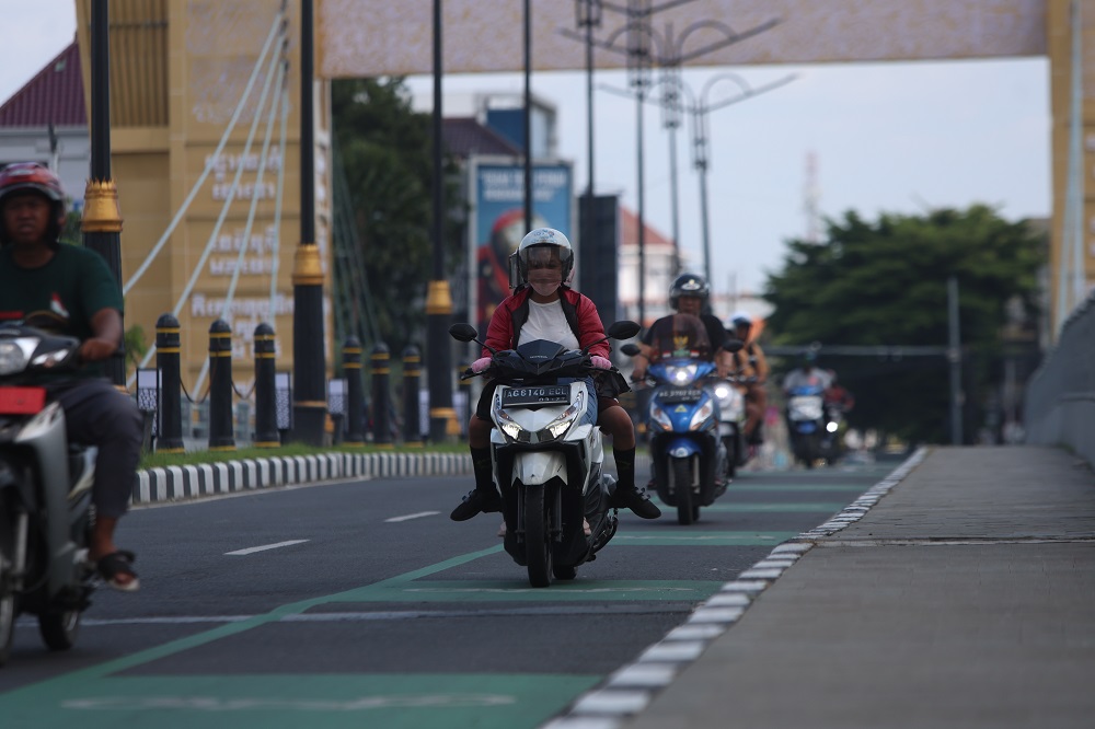 Pengendara motor ketika melintas di Jembatan Brawijaya. Pemakaian masker bisa mencegah penularan TBC maupun penyakit gangguan pernapasan lainnya.