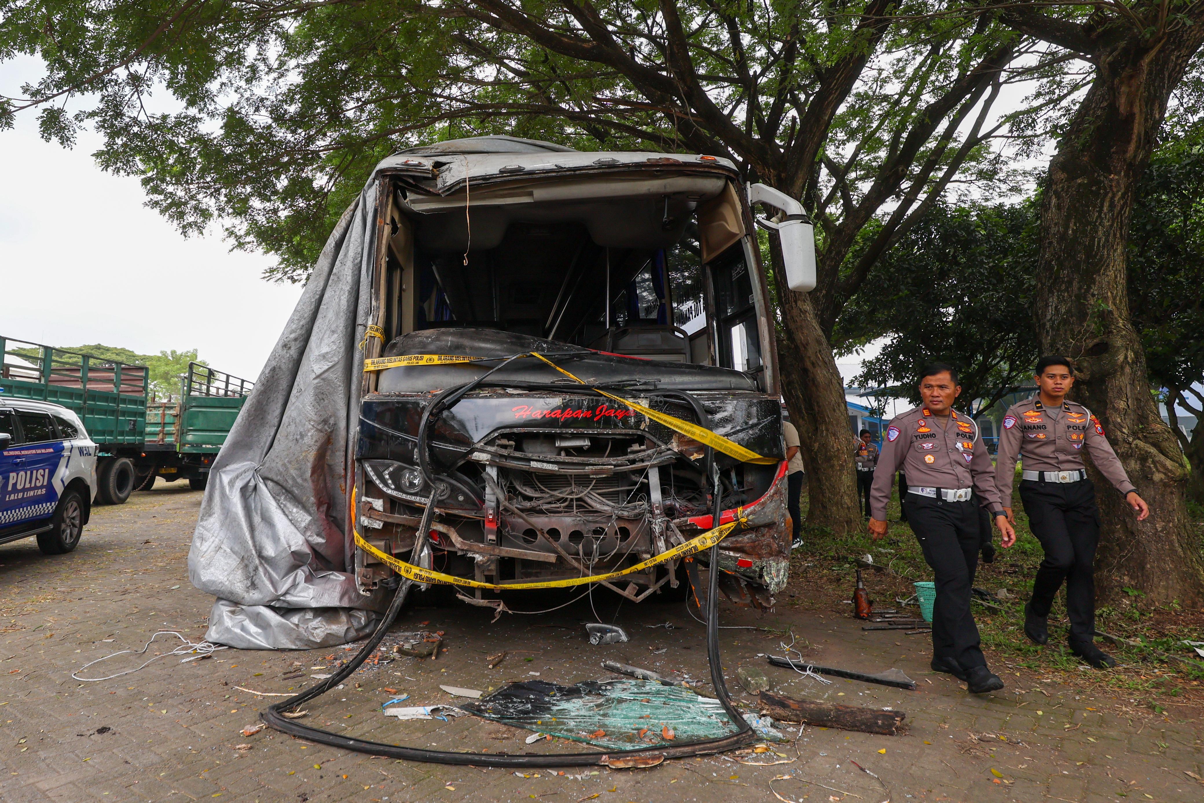 Petugas Satlantas Polres Kediri Kota mengecek armada bus Harapan Jaya yang ringsek dan kini diamankan di Terminan Tamanan Kota Kediri.