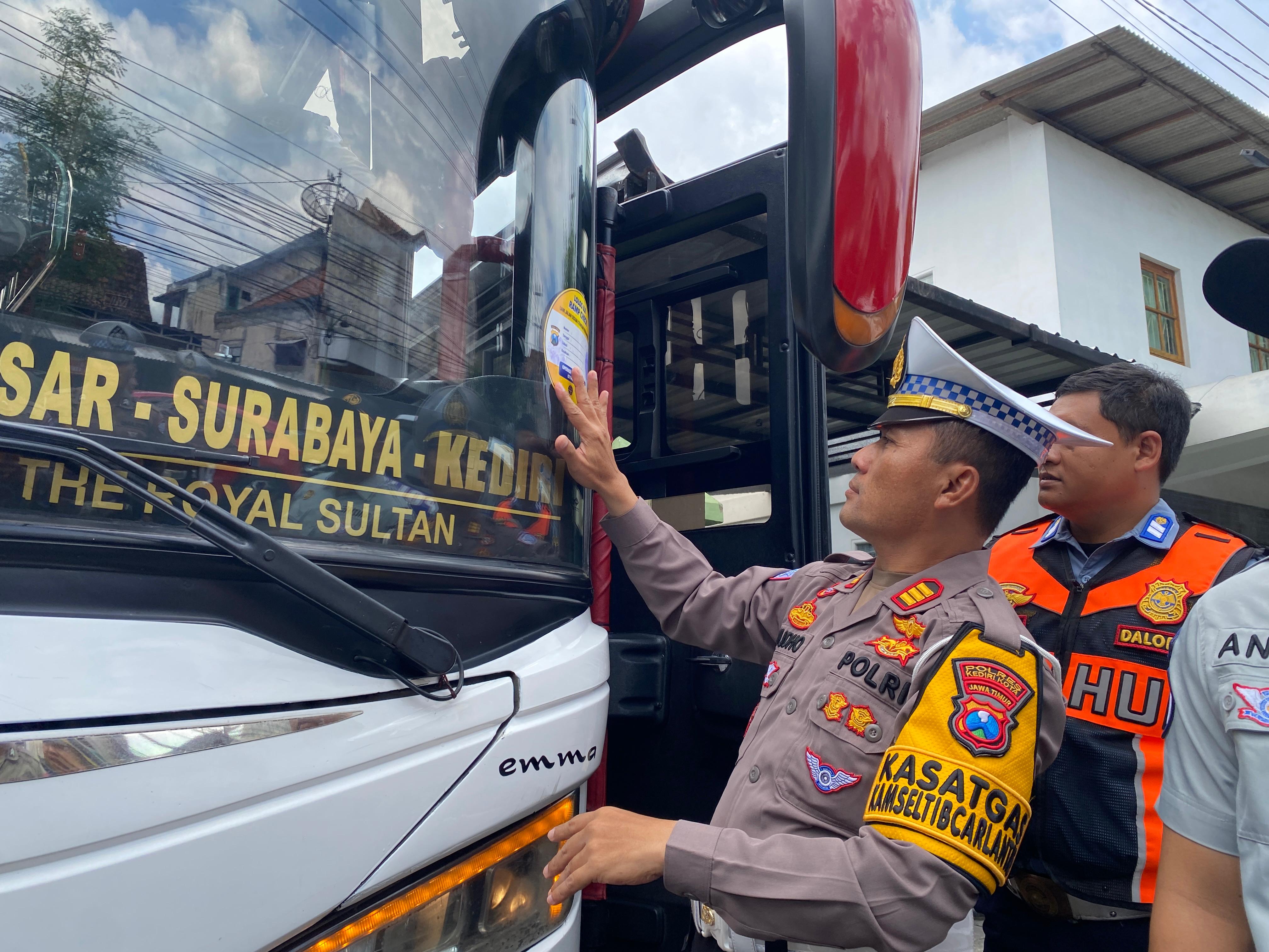 ANTISIPASI: Kasatlantas Polres Kediri Kota AKP Tutud Yudho Prastyawan memasang stiker tanda lolos uji ramp check armada jelang Ramadhan.