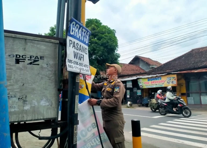 Satpol PP melakukan penertiban spanduk yang tidak sesuai aturan. (Foto: Asad MS)