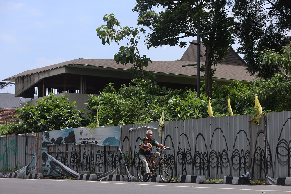 MANGKRAK: Warga melintas di depan Alun-Alun Kota Kediri yang proyek perbaikannya dihentikan pada November 2023 lalu.