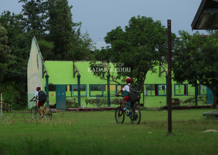 ALIH FUNGSI: Siswa bersepeda di Kawasan SDN 1 Ngablak, Kecamatan Banyakan. Dua ruang SD tersebut akan digunakan untuk KDMP. (Foto: WAHYU ADJI F/JPRK)