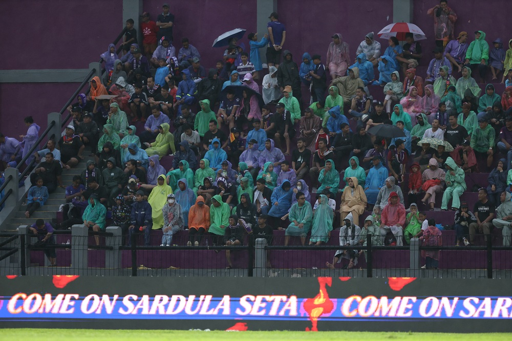 Suporter Persik Kediri tetap setia memberi dukungan meski diguyur hujan.