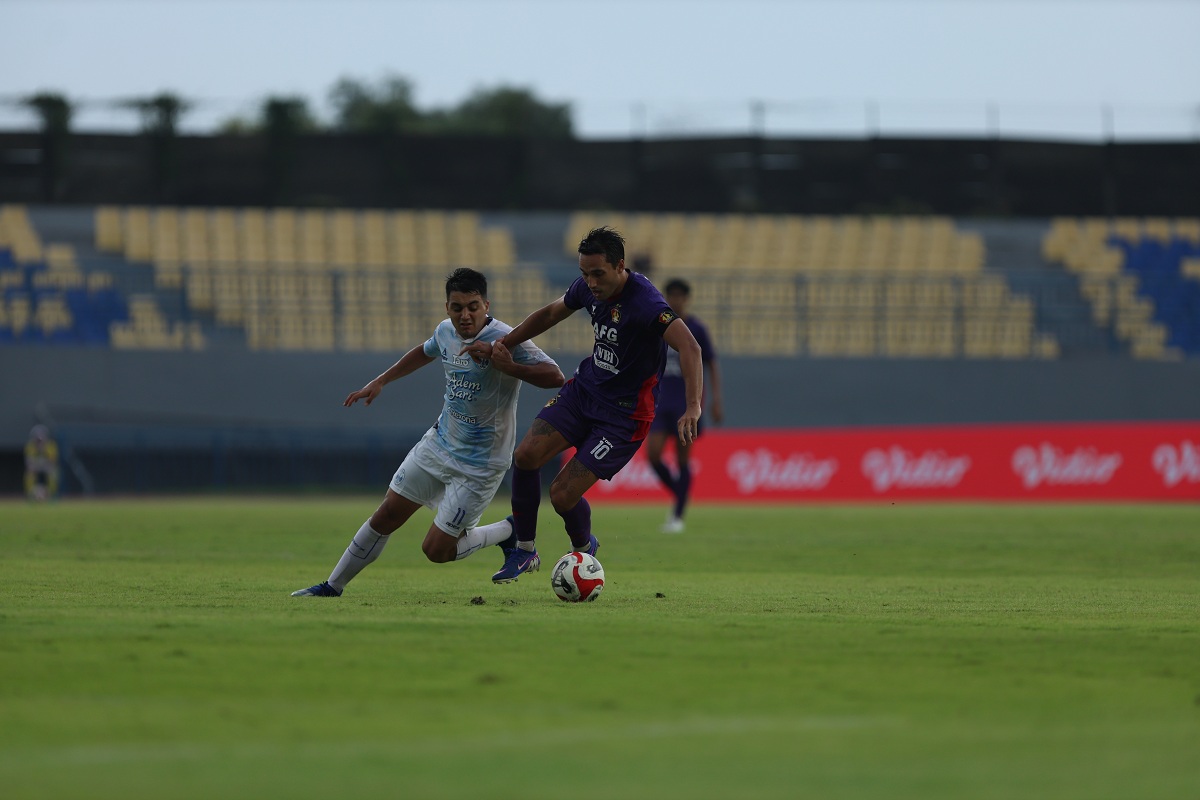 Ezra Walian saat berebut bola dengan Ezequiel Vidal dalam laga Persik vs PSIM Yogyakarta.