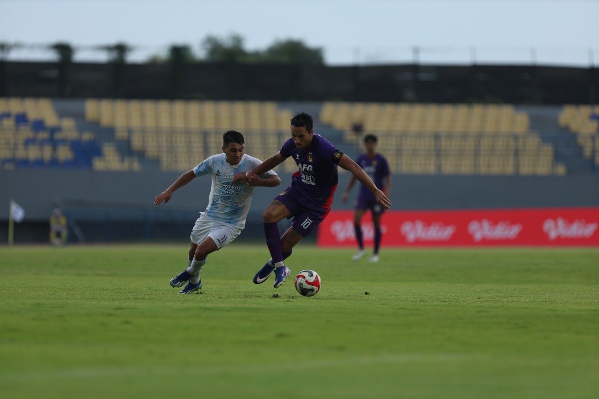 Pemain Persik Kediri Ezra Walian berebut bola dengan pemain PSIM Yogyakarta Ezequiel Vidal.