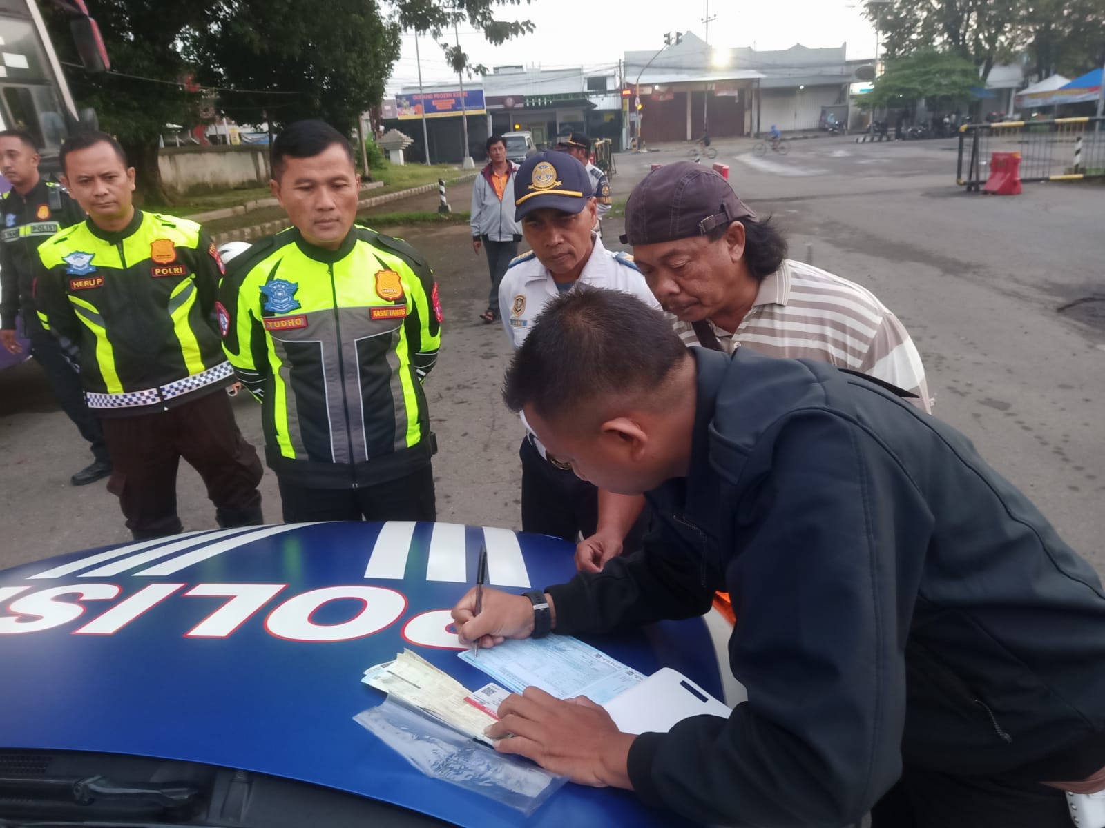 TAK JERA: Sopir bus YK, 50, menandatangani surat tilang yang diberikan Satlantas Polres Kediri Kota. Polisi juga menyita armada bus tersebut.  &nbsp;