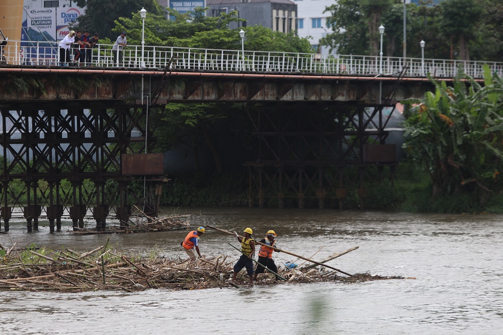 Tim dari Pemkot Kediri dan PJT turun ke kaki Jembatan Lama untuk membersihkan tumpukan batang, ranting pohon, dan sampah yang menggunung dan mengancam kekuatan struktur Jembatan Lama, Rabu (18/2).