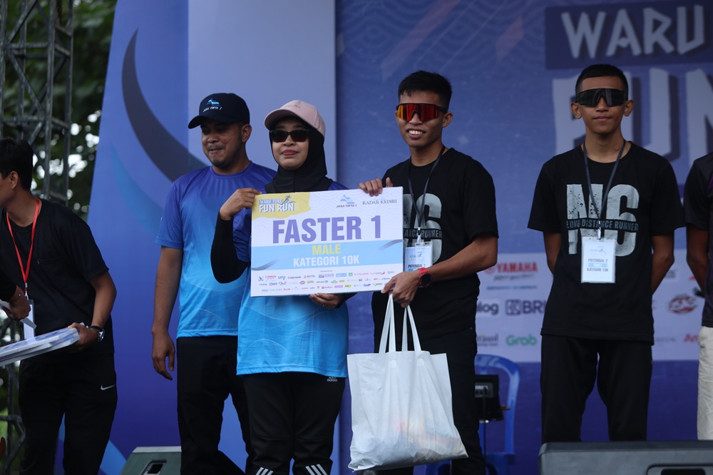 Rio, menerima bingkisan sebagai faster 10K Waru Turi Fun Run dari perwakilan PJT.