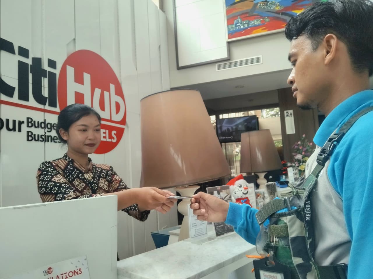 Resepsionis memberikan kunci kamar ke tamu hotel (Diana Yunita)