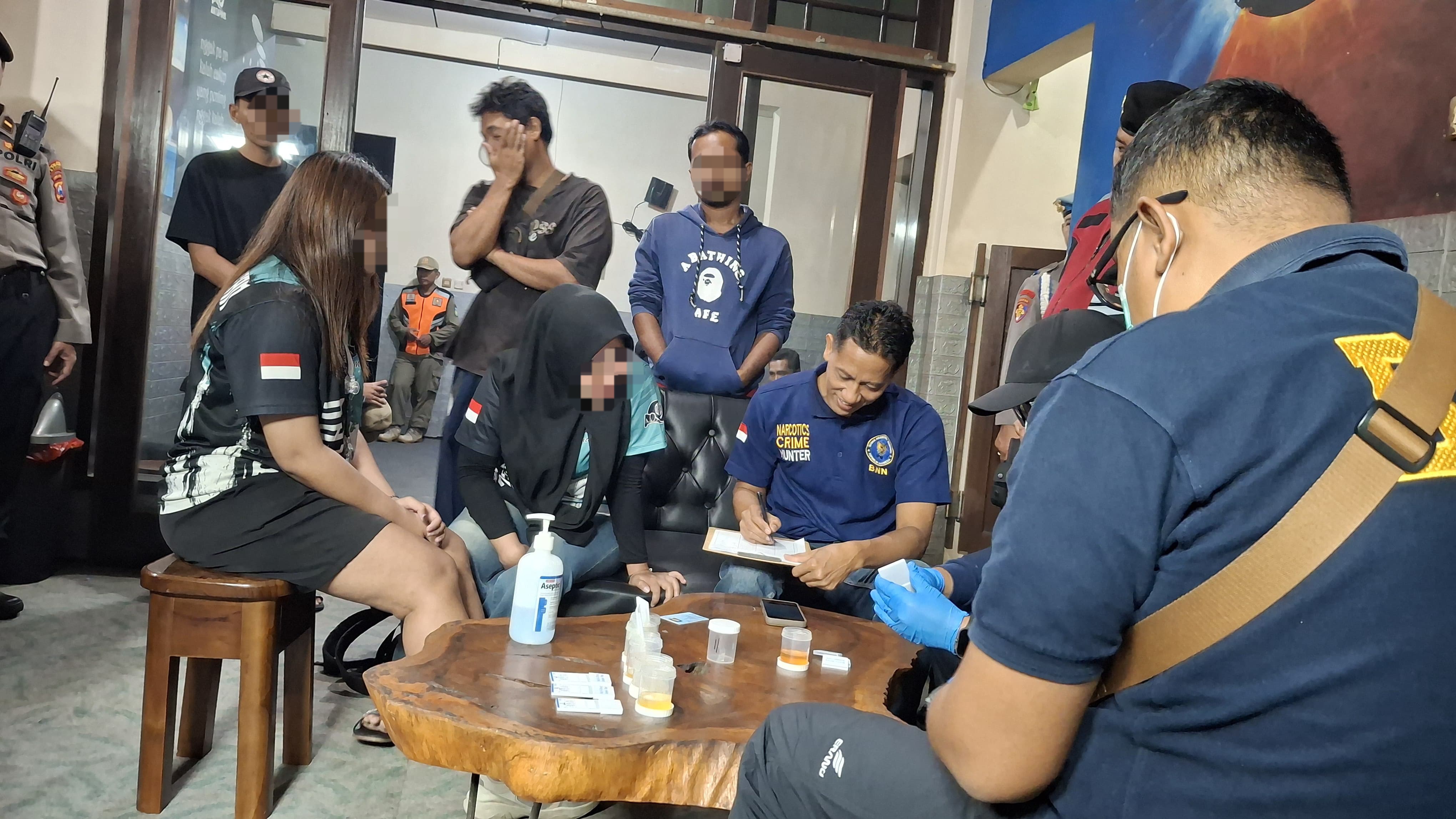Petugas gabungan melakukan pendataan dan pemeriksaan tes urine.