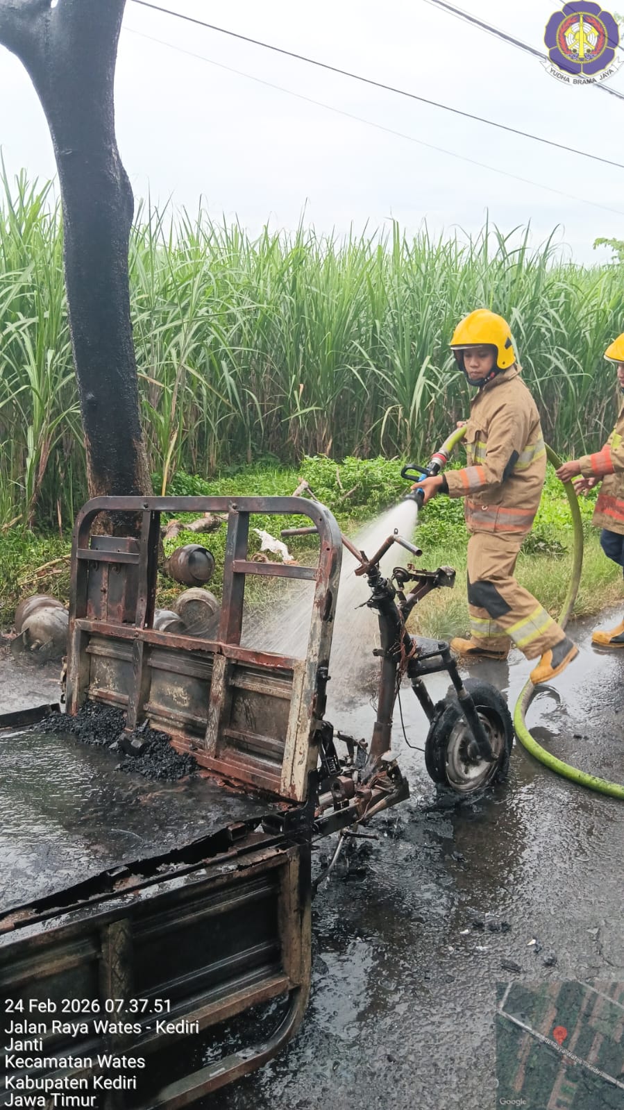 Petugas memadamkan api di kendaraan roda tiga.