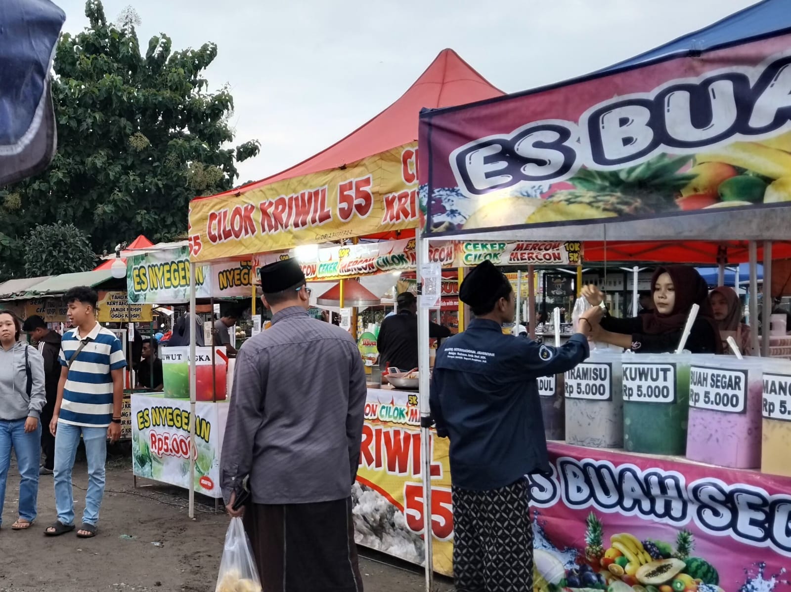 Penjual takjil melayani konsumen membeli es jelang berbuka (Diana Yunita)