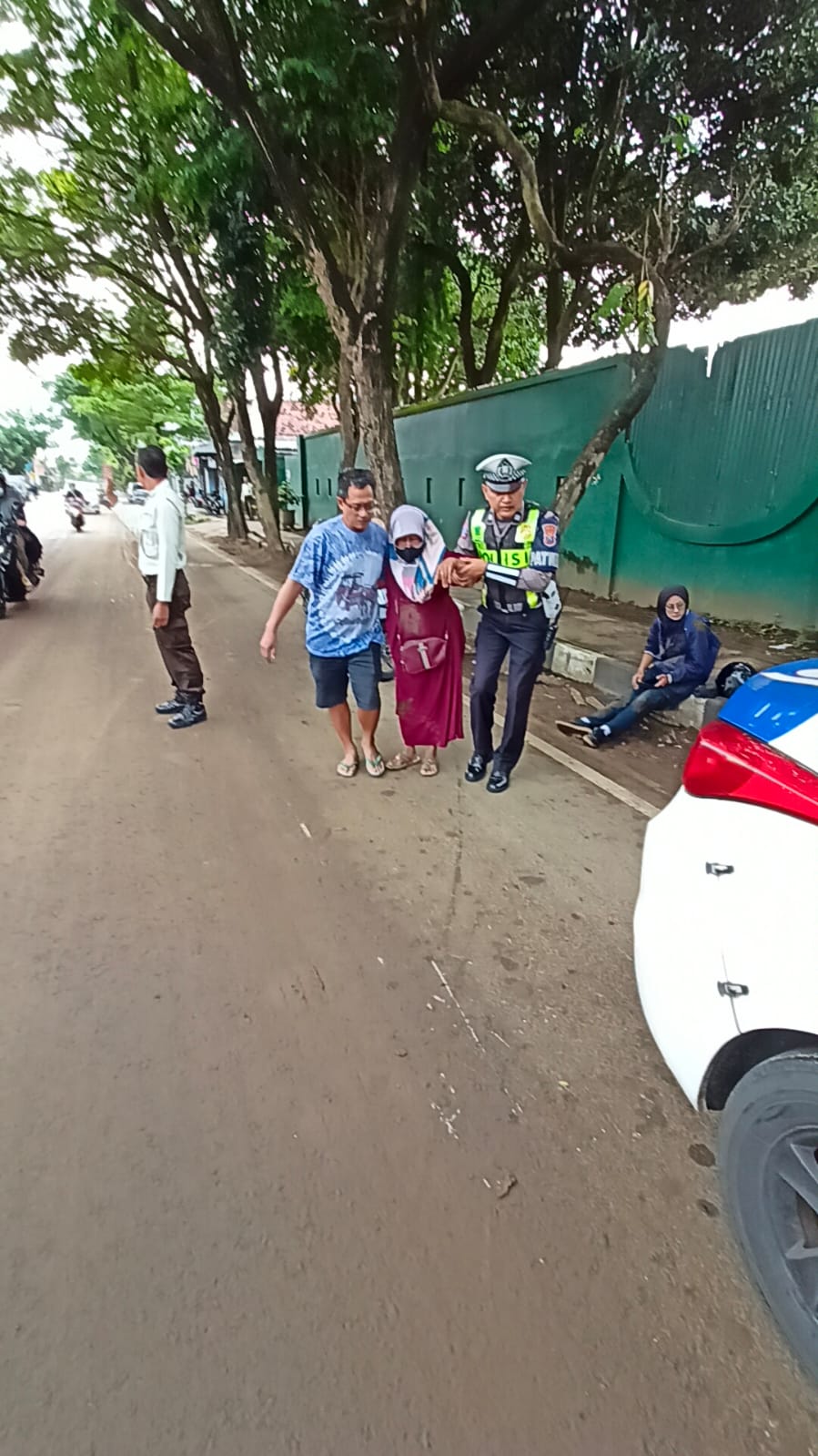 Aiptu Agung Broto sedang mengevakuasi korban menuju Puskesmas Campurejo.