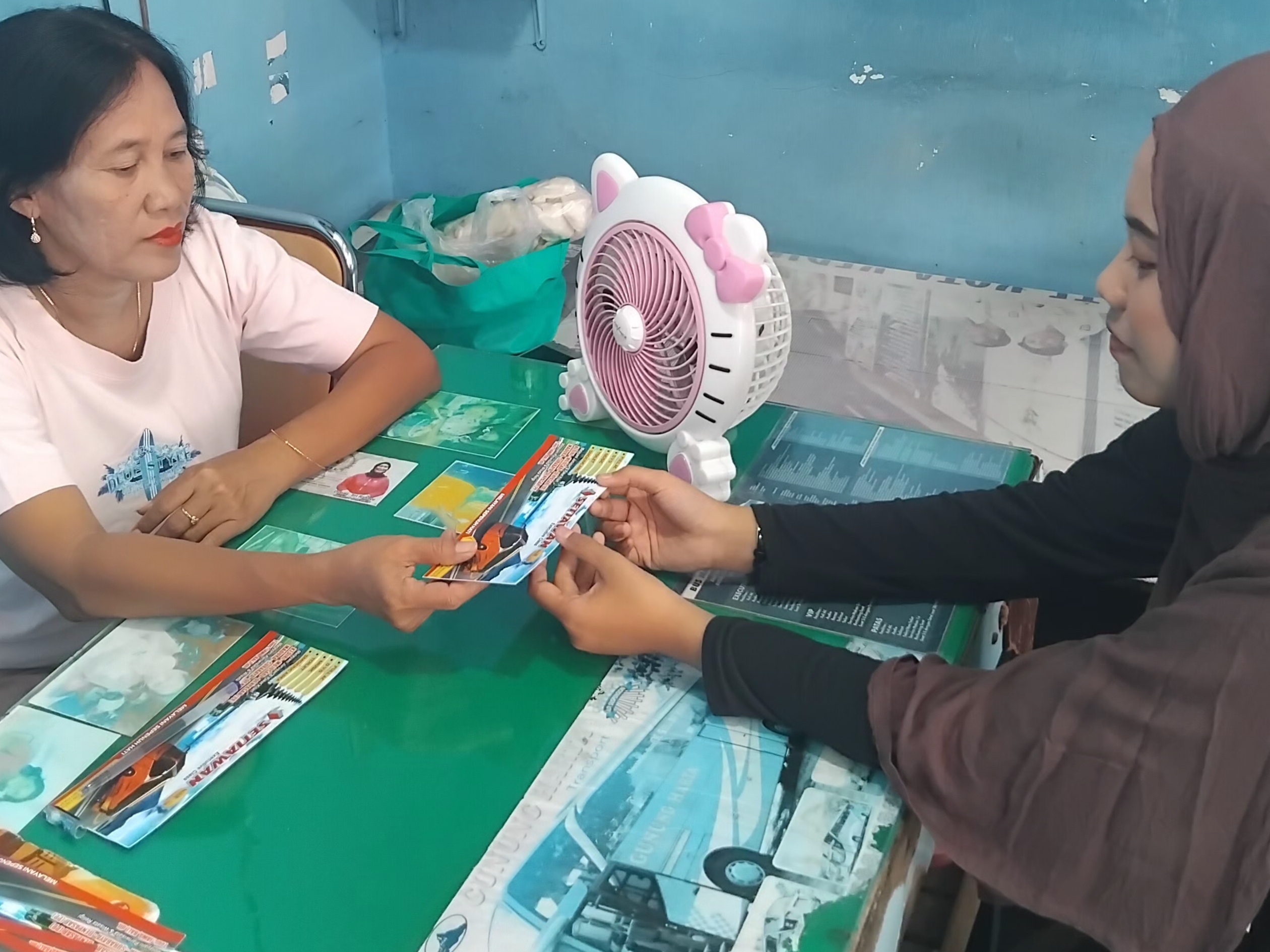 Petugas PO Bus memberikan tiket kepada penumpang (Diana Yunita/JPRK)