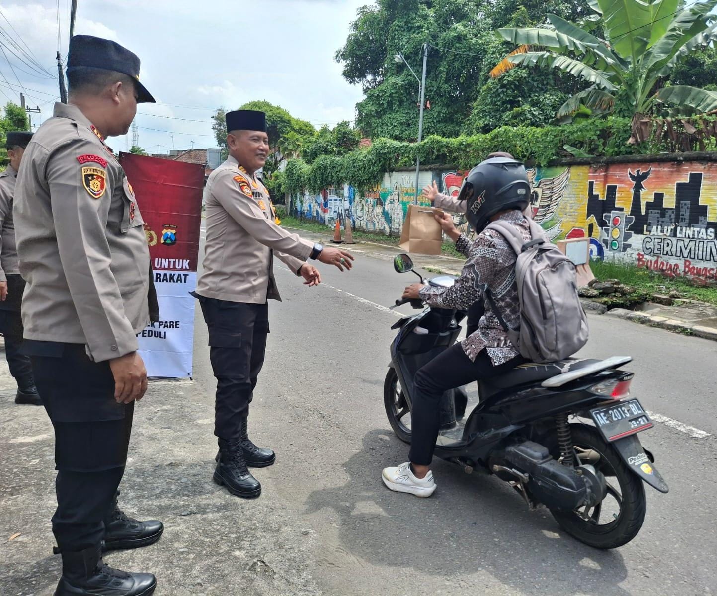 BERBAGI: Kapolsek Pare AKP Rudi Darmawan membagikan takjil kepada pengendara motor di depan Mako Polsek Pare, Jalan Semeru Nomor 18, Pare (1/3). (Foto: Polsek Pare)