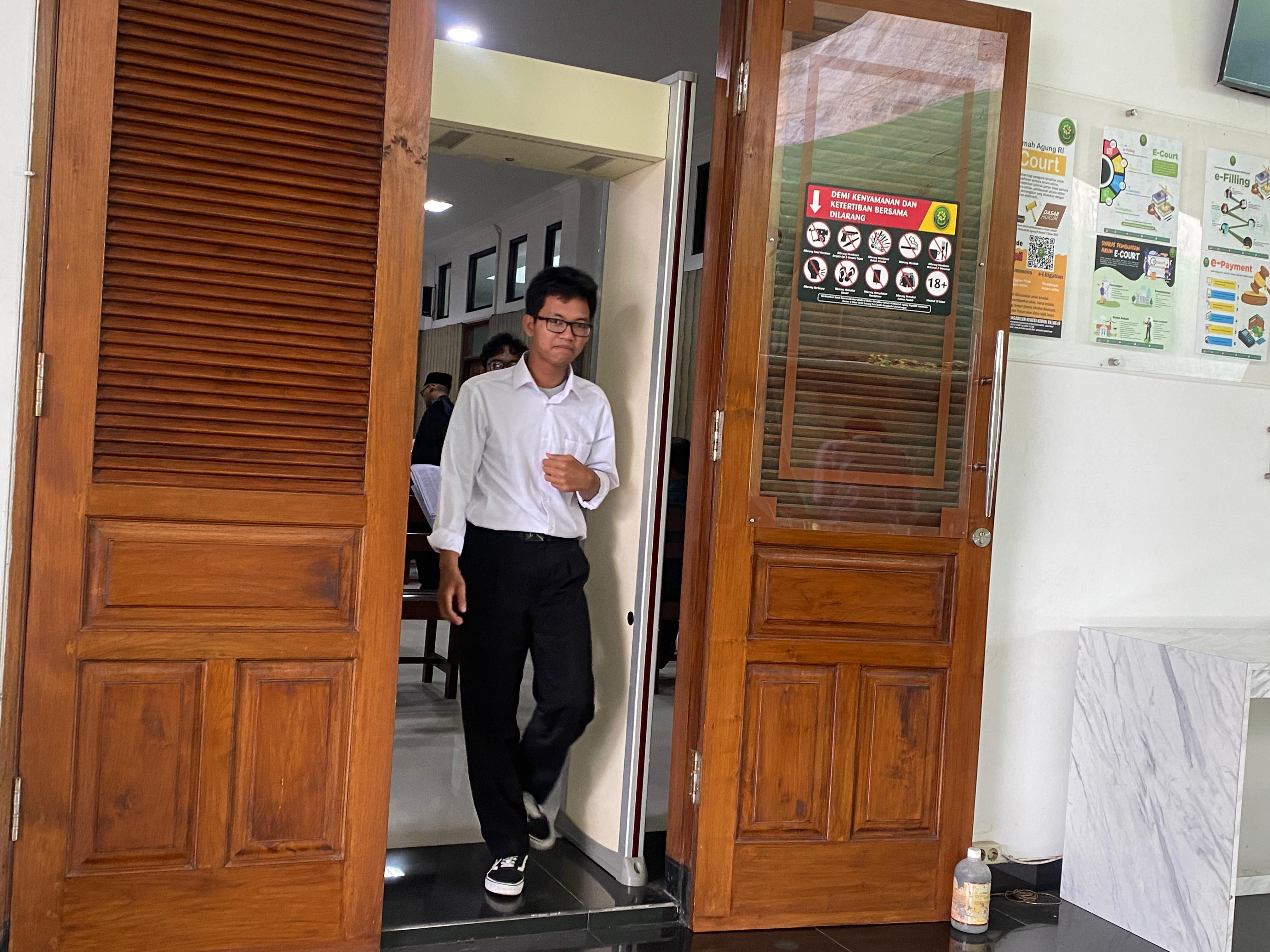 Terdakwa Faiz keluar dari ruang sidang Cakra PN Kediri. 