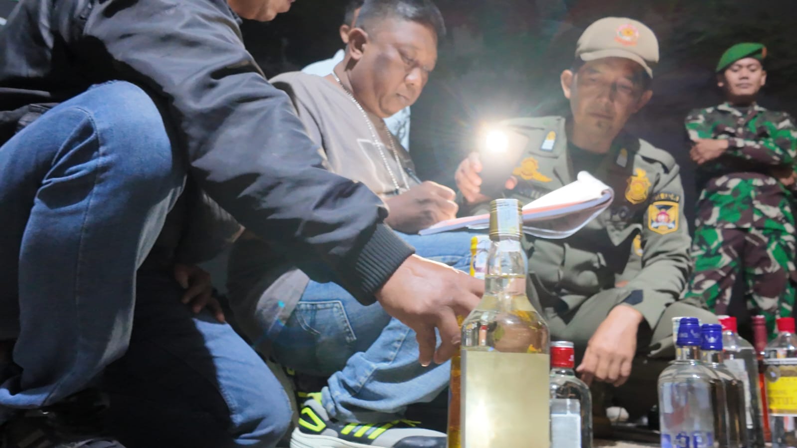 Petugas mendata botol miras yang dijual secara ilegal di salah satu warung yang ada di Kota Kediri.