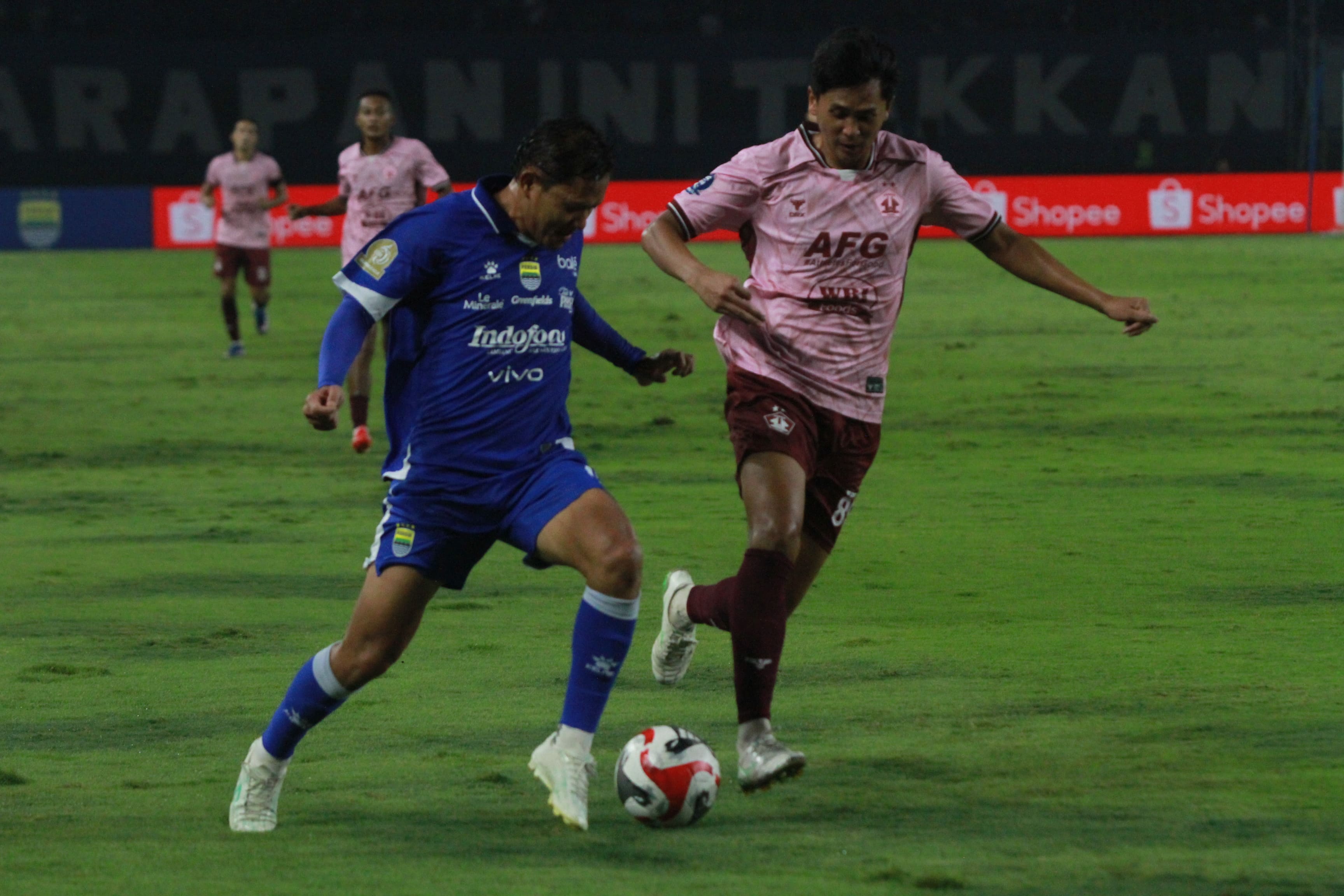 Bek Persik Kediri M. Firly berusaha menghentikan laju gelandang Persib Bandung Adam Alis.