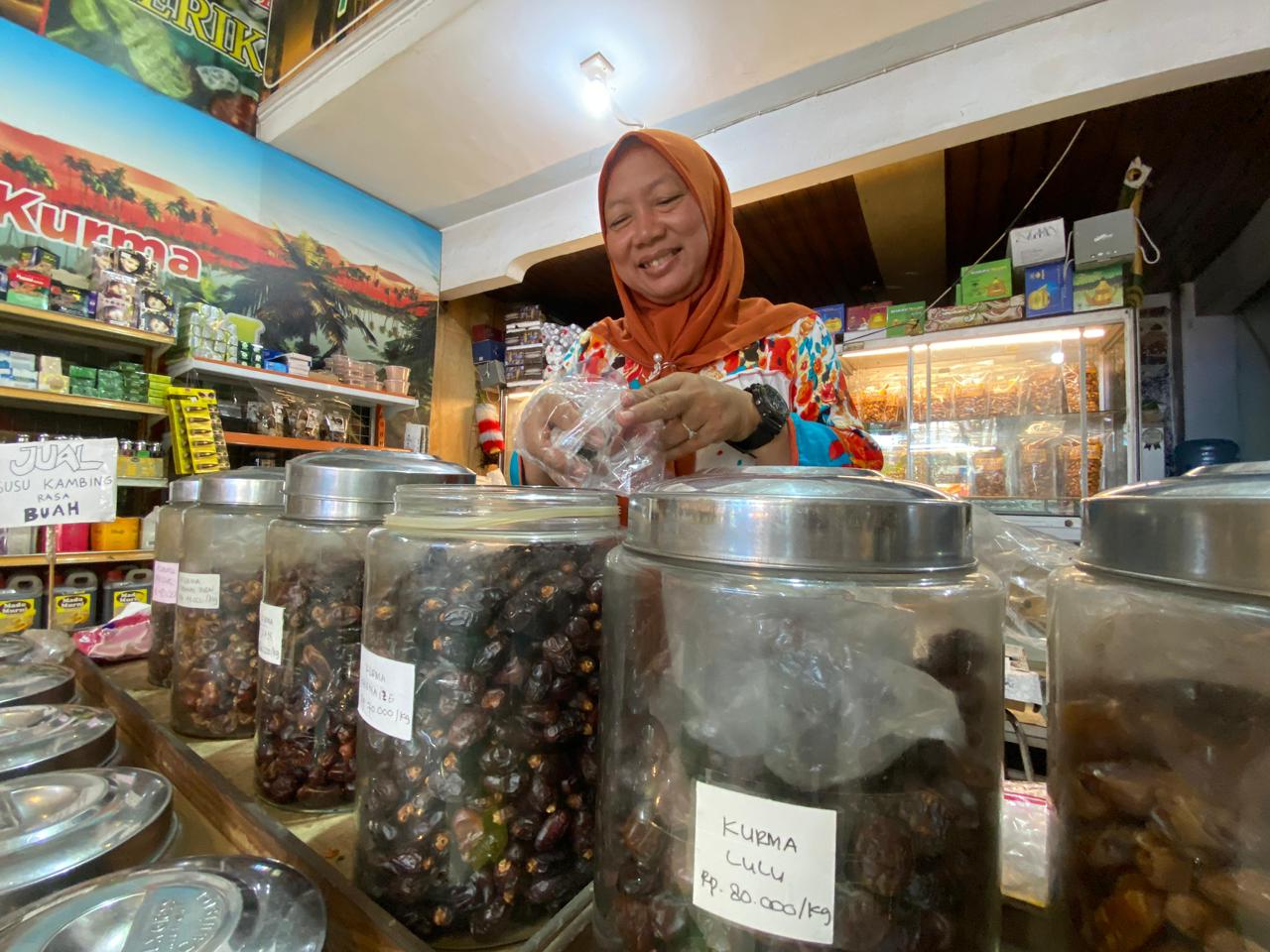 Pedagang kurma sedang melayani pembeli. Saat ini harganya lebih mahal dibandingkan tahun sebelumnya.