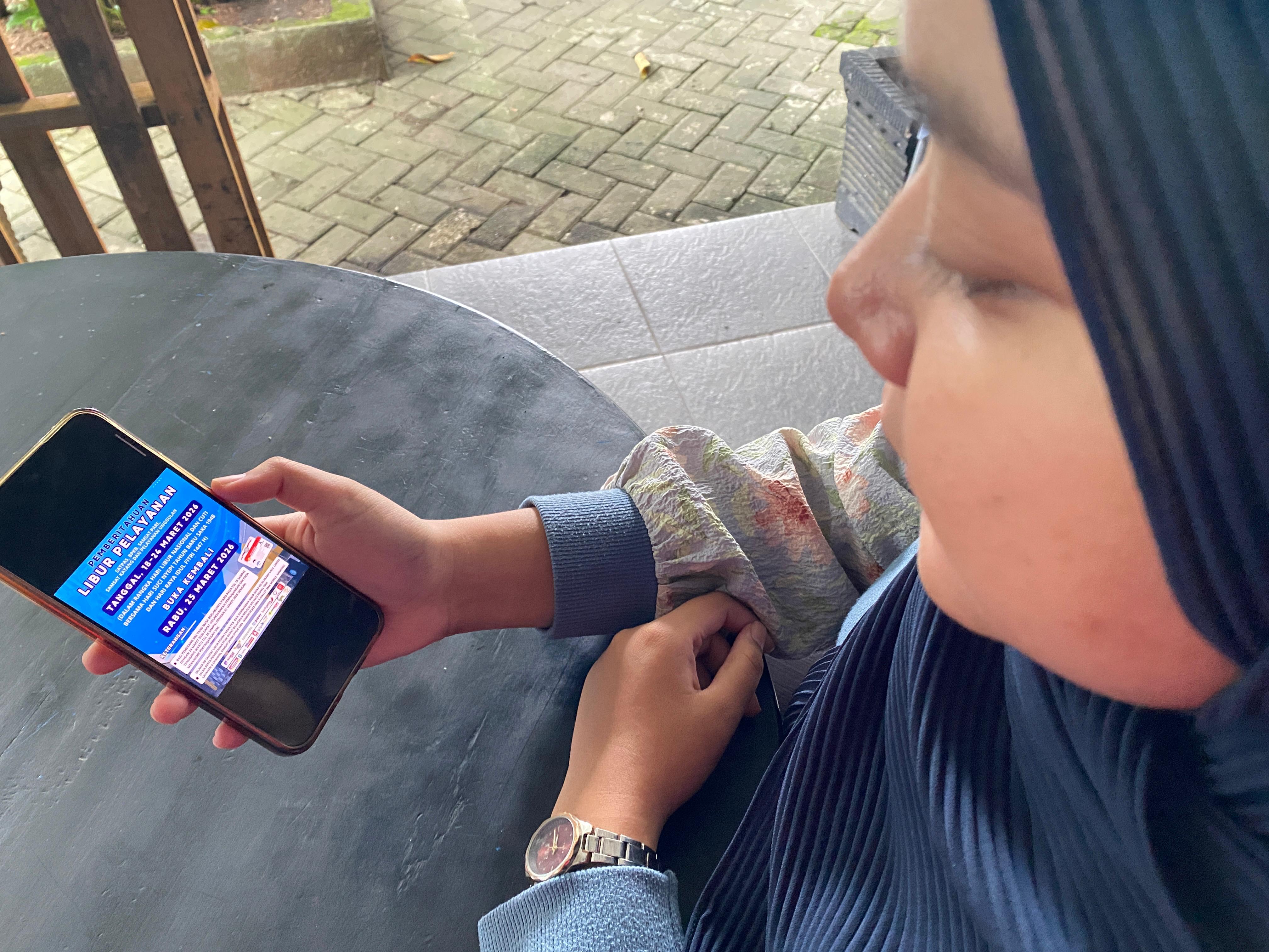 LIBUR: Masyarakat sedang melihat flyer pelayanan Satpas SIM dan Samsat yang libur.