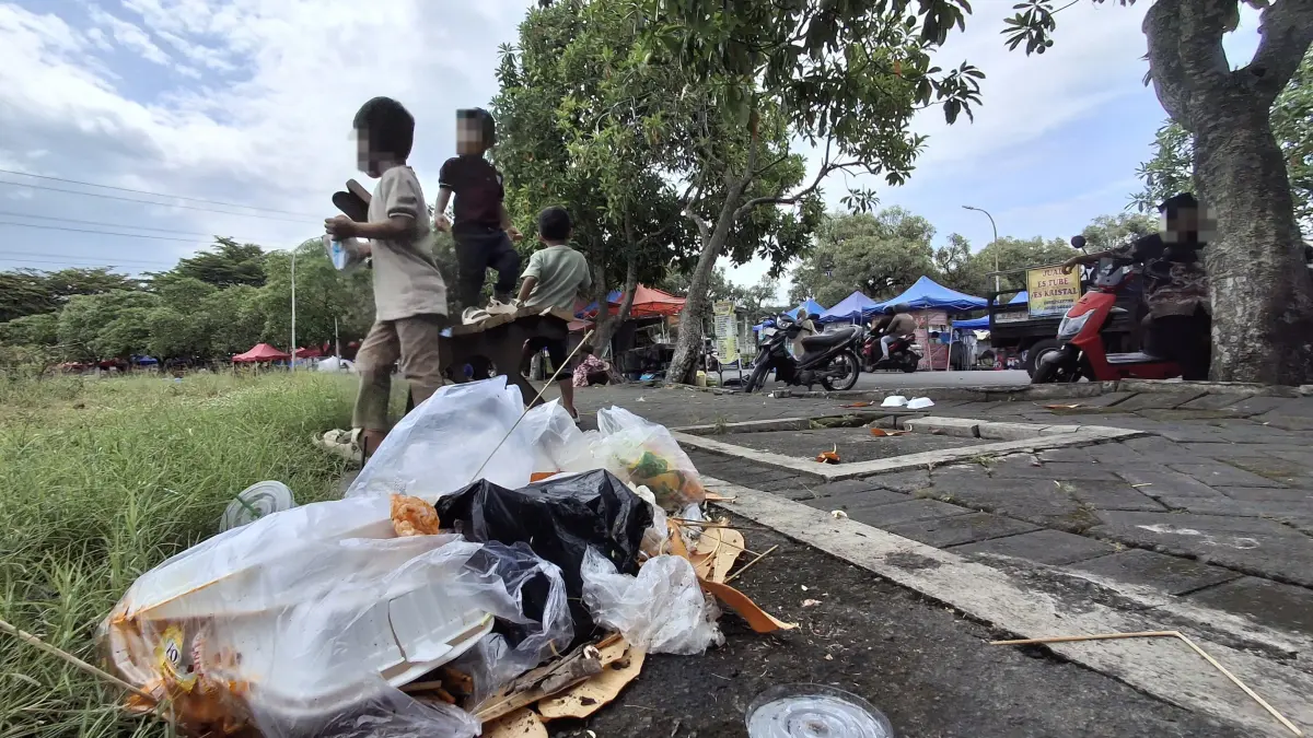 TAK BERTANGGUNG JAWAB: Pengunjung kawasan SLG membuang sampah bekas bungkus makanan di tepi jalan. Meski ada ratusan kotak sampah, masih banyak masyarakat yang abai dengan kebersihan.
