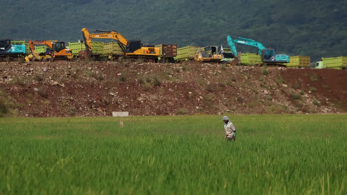 Ilustrasi petani di Kelurahan Bujel, Kota Kediri, yang mengelola sawahnya di tengah proyek pembangunan jalan tol. (Foto: Wahyu Adji)