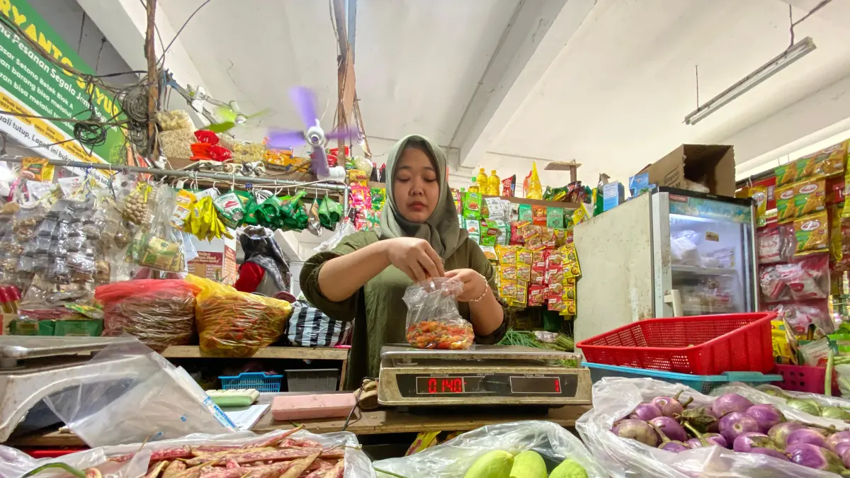 PEDAS: Pedagang di Pasar Setonobetek Kota Kediri melayani pembeli cabai rawit di tokonya. Harga cabai kini relatif masih tinggi. (HILDA NURMALA RISANI/JPRK)