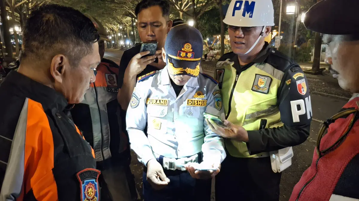 Petugas memeriksa karcis parkir di kawasan SLG Kediri. (Asad MS/JPRK)