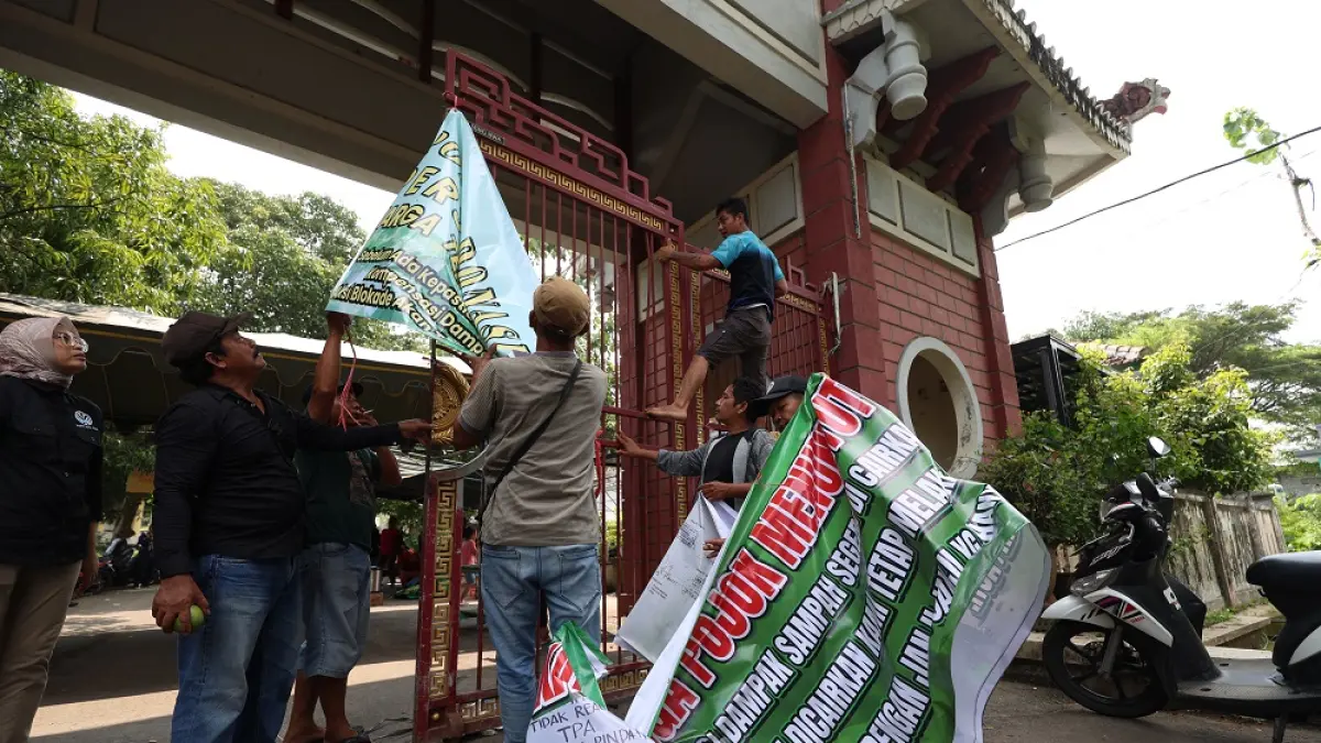 JALAN TENGAH: Warga mengambili banner yang selama beberapa hari terakhir terpasang di jalan pintu masuk ke area TPA Klotok setelah tempat pembuangan akhir itu dibuka kembali kemarin (7/4) siang. 