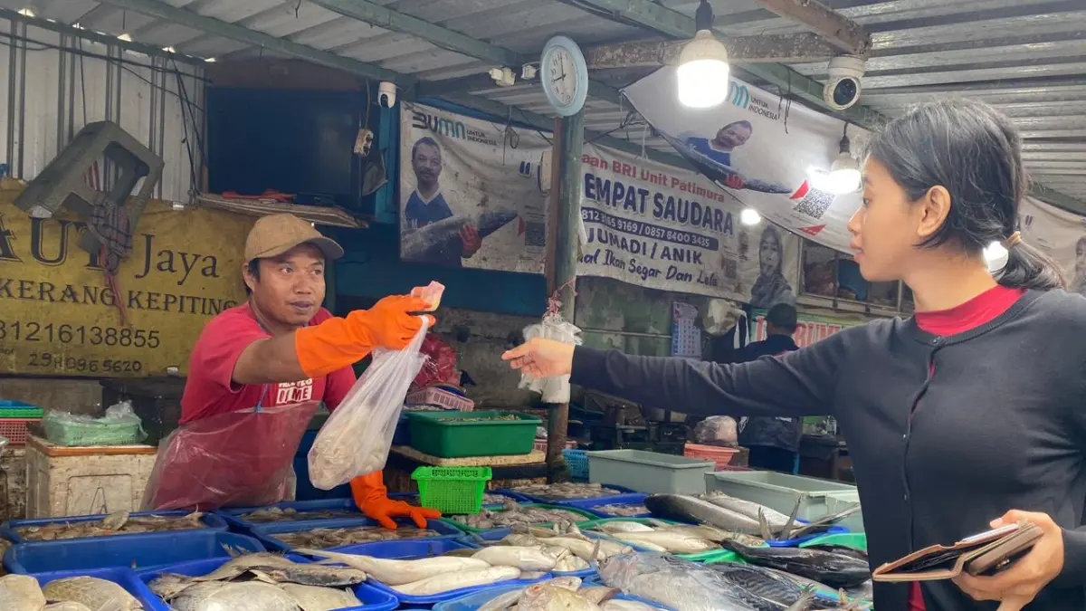 TERKENDALA CUACA: Pedagang ikan laut di Pasar Setonobetek Kota Kediri melayani pembeli. Pasokan ikan laut berkurang imbas cuaca ekstrem. (HILDA NURMALA RISANI/JPRK)