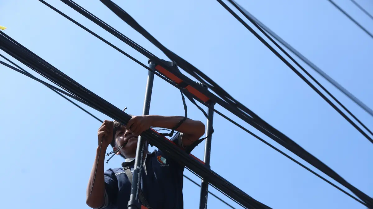 Ilustrasi petugas merapikan kabel-kabel optik yang semrawut di Kota Kediri. Tahun ini, DPRD Kota Kediri godok tiga raperda prioritas. Salah satunya penyelenggaraan jalan kota. (Foto: Wahyu Adji)