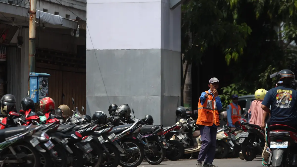 JURU PARKIR: Salah seorang jukir dari Dishub Kota Kediri sedang bertugas di Jalan Dhoho.