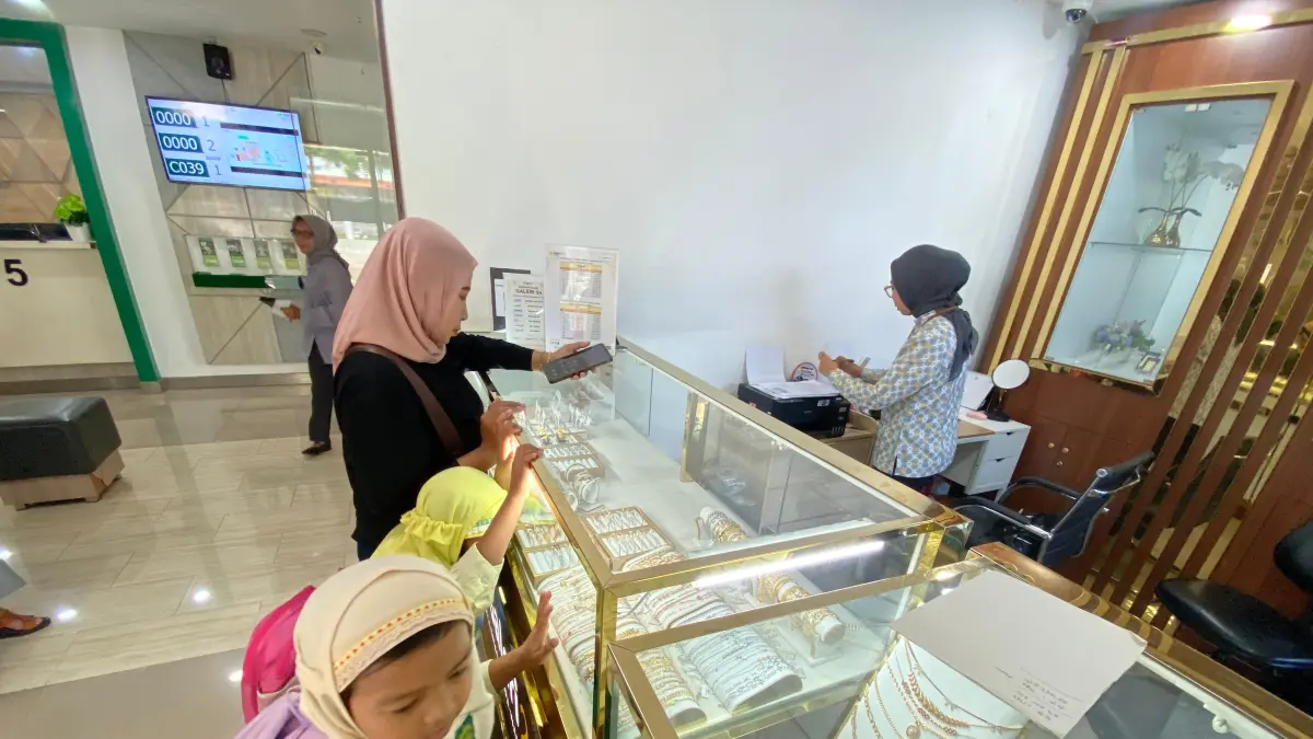 BERKILAU : Dua anak melihat emas yang berkilau di etalase. Saat ini harga emas mulai merangkak naik. (Hilda Nurmala Risani/JPRK)