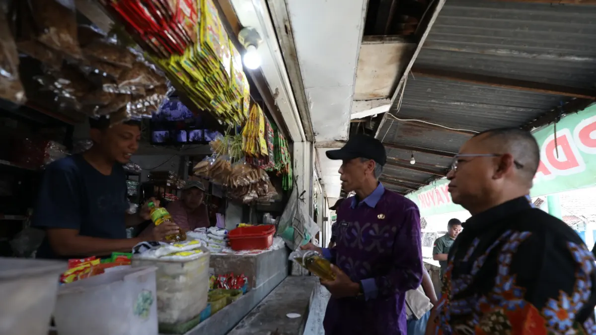 LANGKA: Kepala Disperdagin Kota Kediri M. Ridwan (kanan) mengecek stok Minyakita yang di pasaran sulit ditemukan menyusul pengurangan stok dari distributor. (Wahyu Adji/JPRK