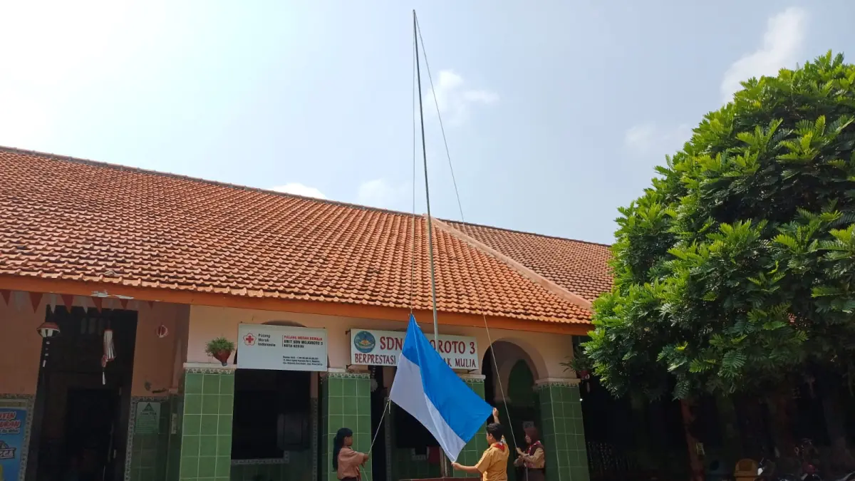 Siswa SDN Mojoroto 3 berlatih mengibarkan bendera di halaman sekolah dengan imitasi. Bangunan sekolah itu merupakan peninggalan era kolonial Belanda yang sudah berusia lebih dari 70 tahun. (Foto: Ayu Isma)