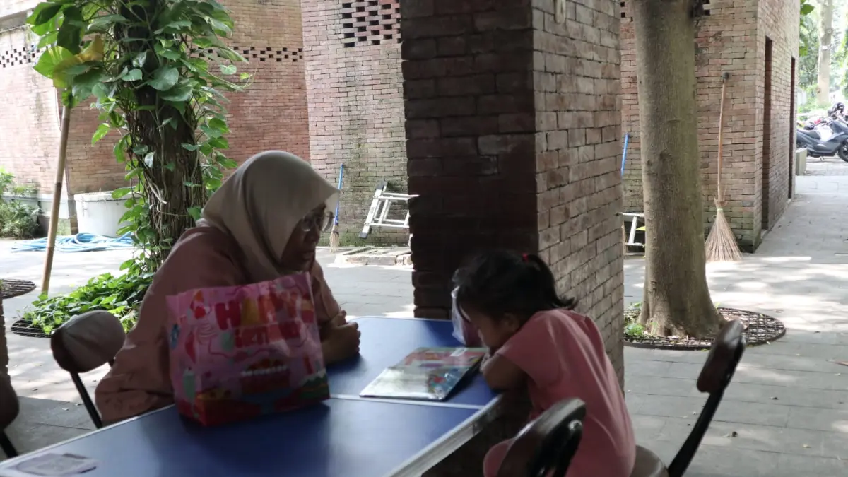 Seorang pengunjung Taman Sekartaji menggunakan fasilitas Disarpus Kota Kediri untuk membaca buku. (Foto: Ayu Isma)