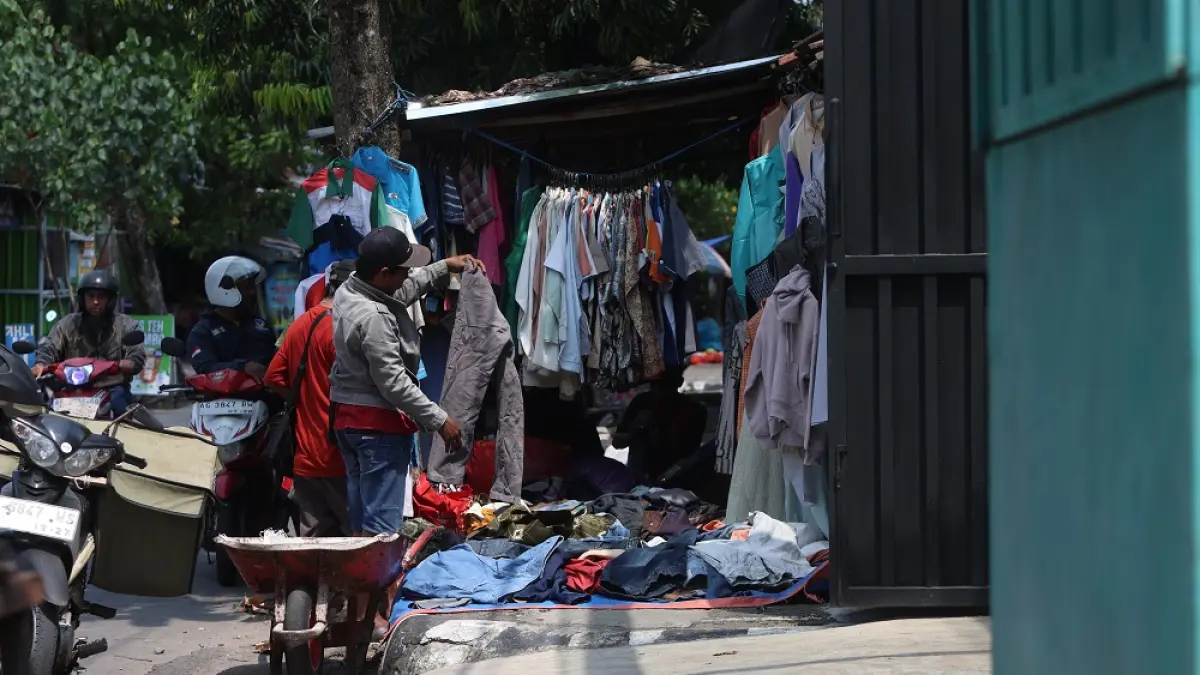 Seorang warga memilih pakaian untuk dibeli di lapak baju Jl Sam Ratulangi. Pemkot Kediri akan segera menertibkan pedagang di ruas jalan itu mulai Mei 2026. (Foto: Wahyu Adji)