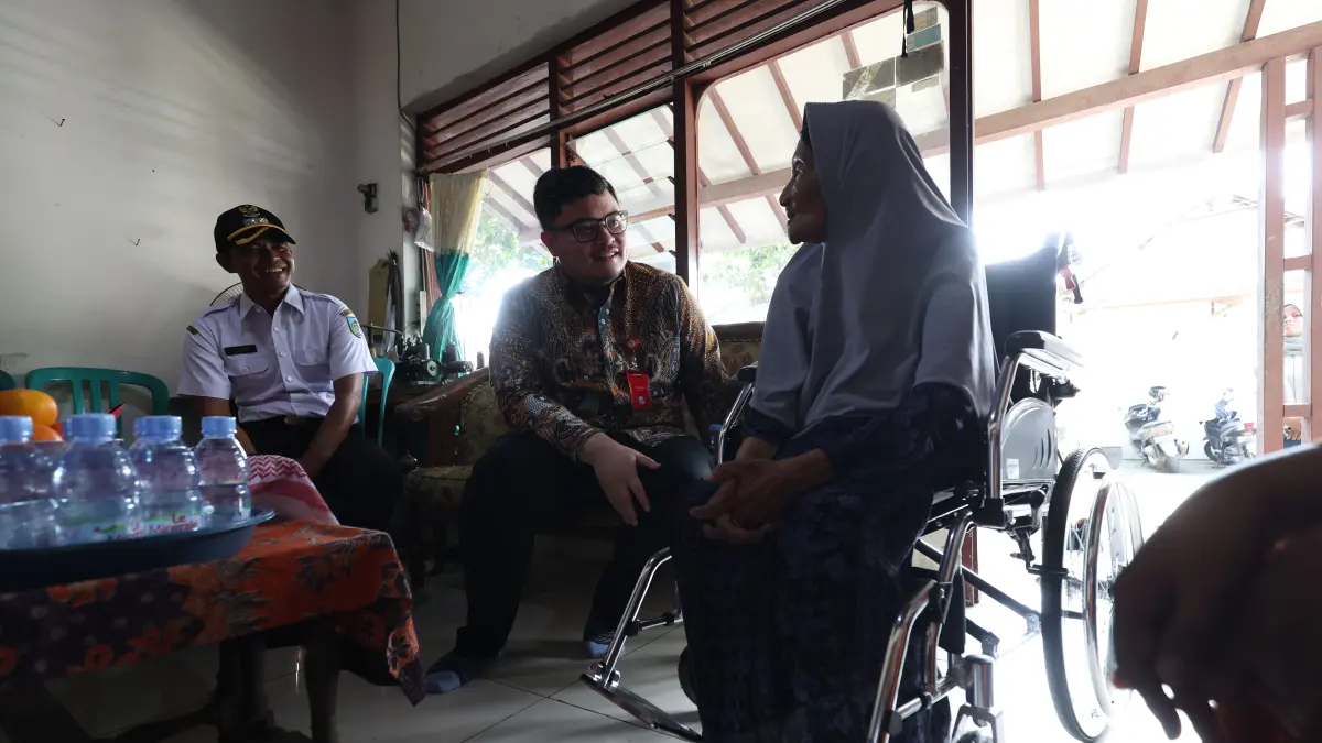 TERENYUH: Bupati Hanindhito Himawan Pramana (baju batik) berbincang dengan Marsiah, CJH tertua di Indonesia asal Desa Bulu Semen. Dhito memberikan bantuan kursi roda, uang, dan bekal makanan kering. (Wahyu Adji/JPRK)