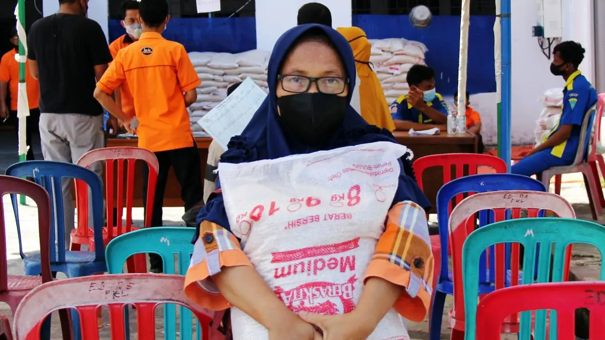 Seorang warga menerima bantuan sembako (ANTARA FOTO/Aswaddy Hamid/foc.)