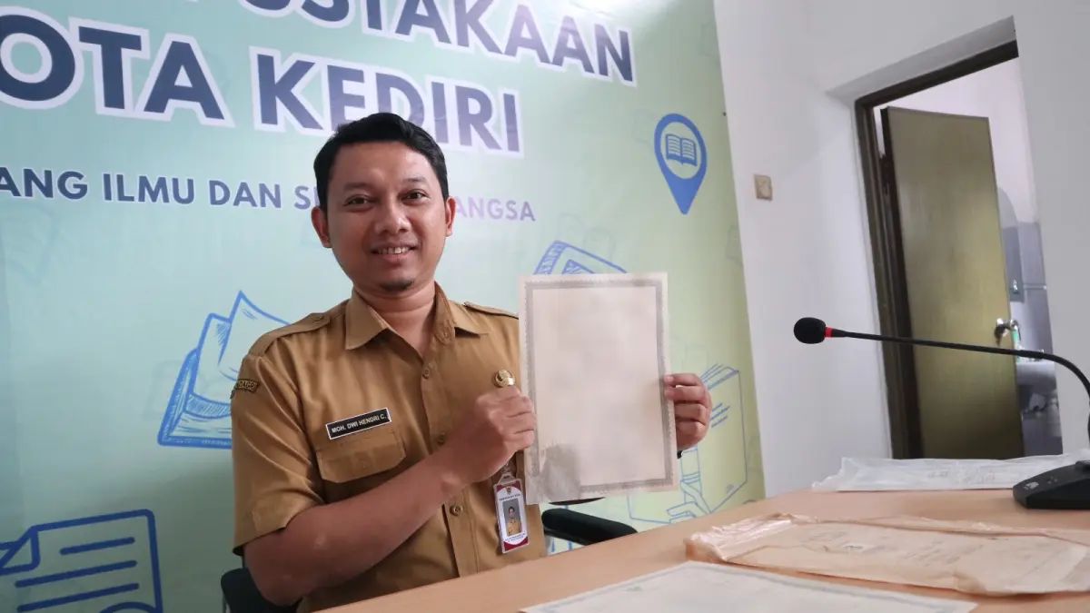 Hendri menunjukkan beberapa ijazah lama yang berhasil diselamatkan melalui program restorasi arsip lama. (Foto: Ayu Isma)