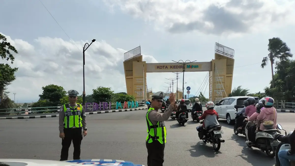 Anggota Satlantas Polres Kediri Kota melakukan pengaturan arus lalu lintas di simpang empat Jembatan Brawijaya. (Hilda/JPRK)