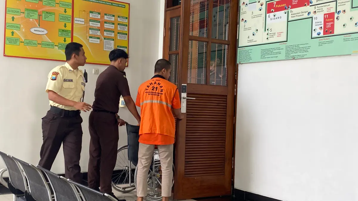 Petugas penjaga tahanan dan Raf mendorong Sumilah menggunakan kursi roda memasuki ruang sidang anak di PN Kediri. (Hilda/JPRK)