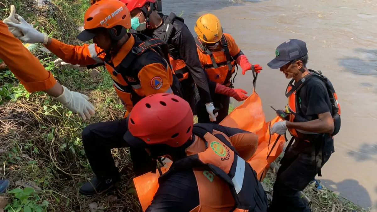 NAHAS: Petugas gabungan mengevakuasi jasad Mustofa, warga Tulungagung yang hanyut di sungai Brantas saat mengikuti momen pladu atau flushing. (Hilda/JPRK)
