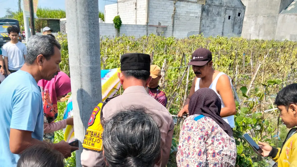Polisi dan warga mengerumuni TKP penemuan bayi di Desa Tugurejo, Ngasem, Kediri. 