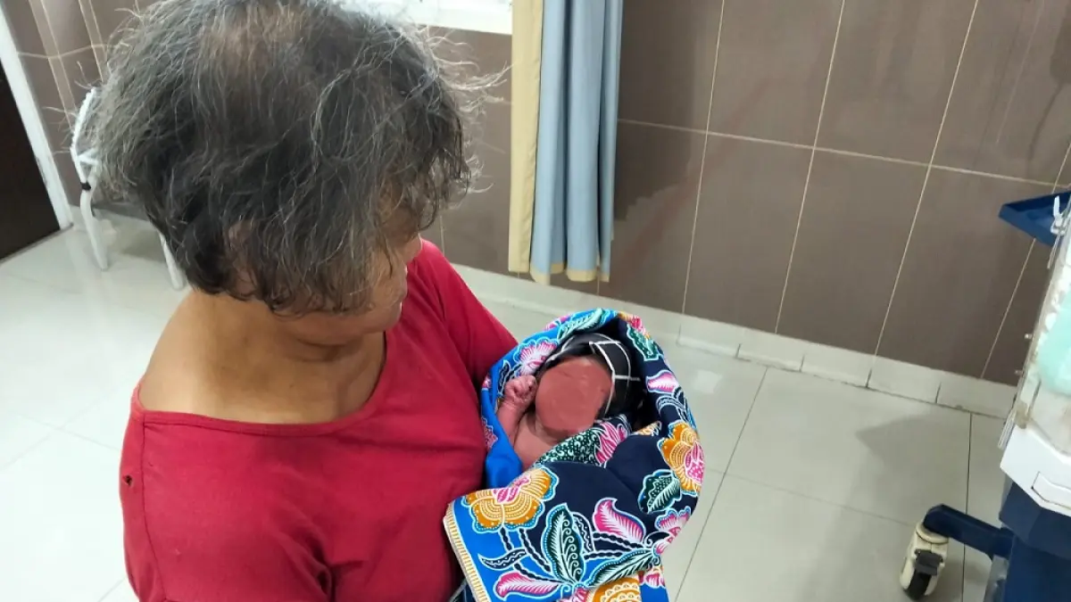 Warga menggendong bayi yang ditemukan di area Kecamatan Ngasem.